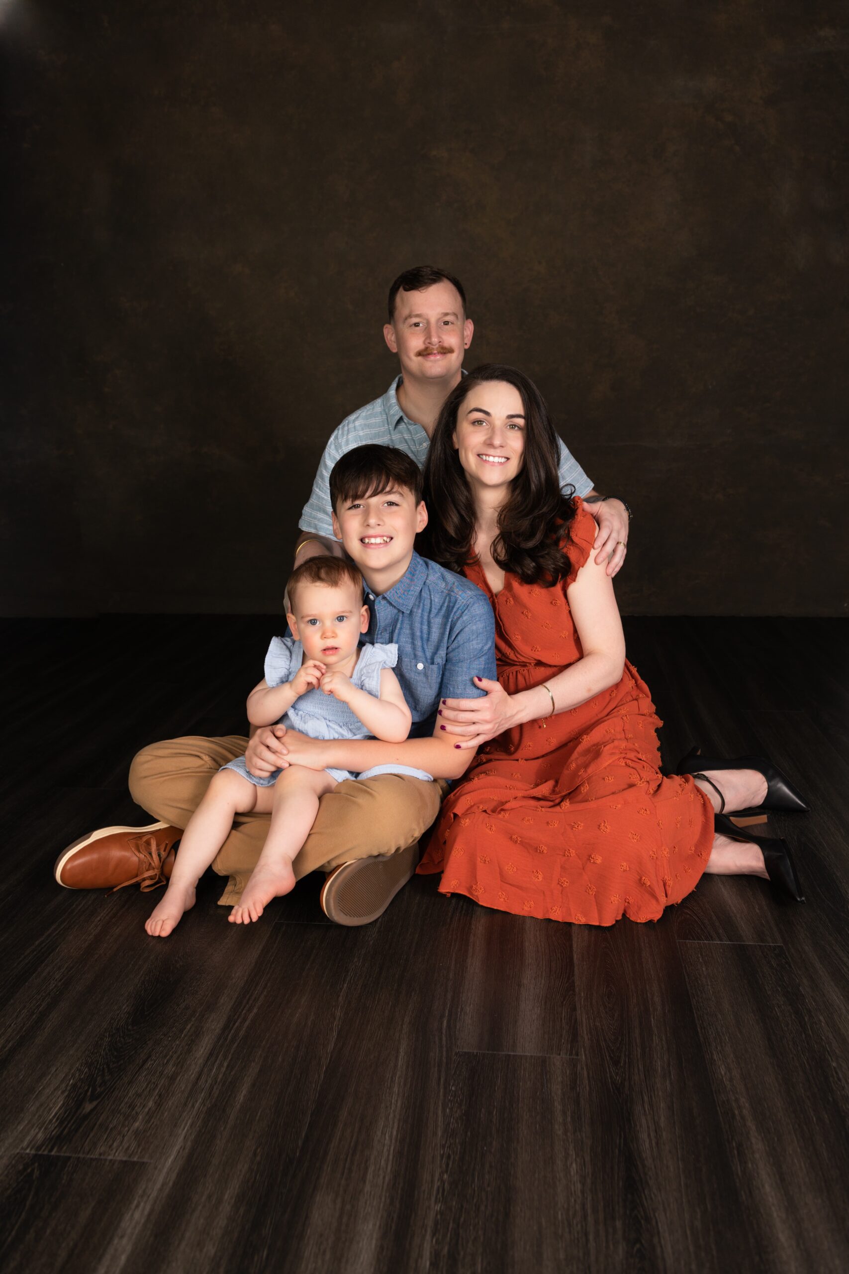 Family with an older son and baby seated during a Dallas studio session