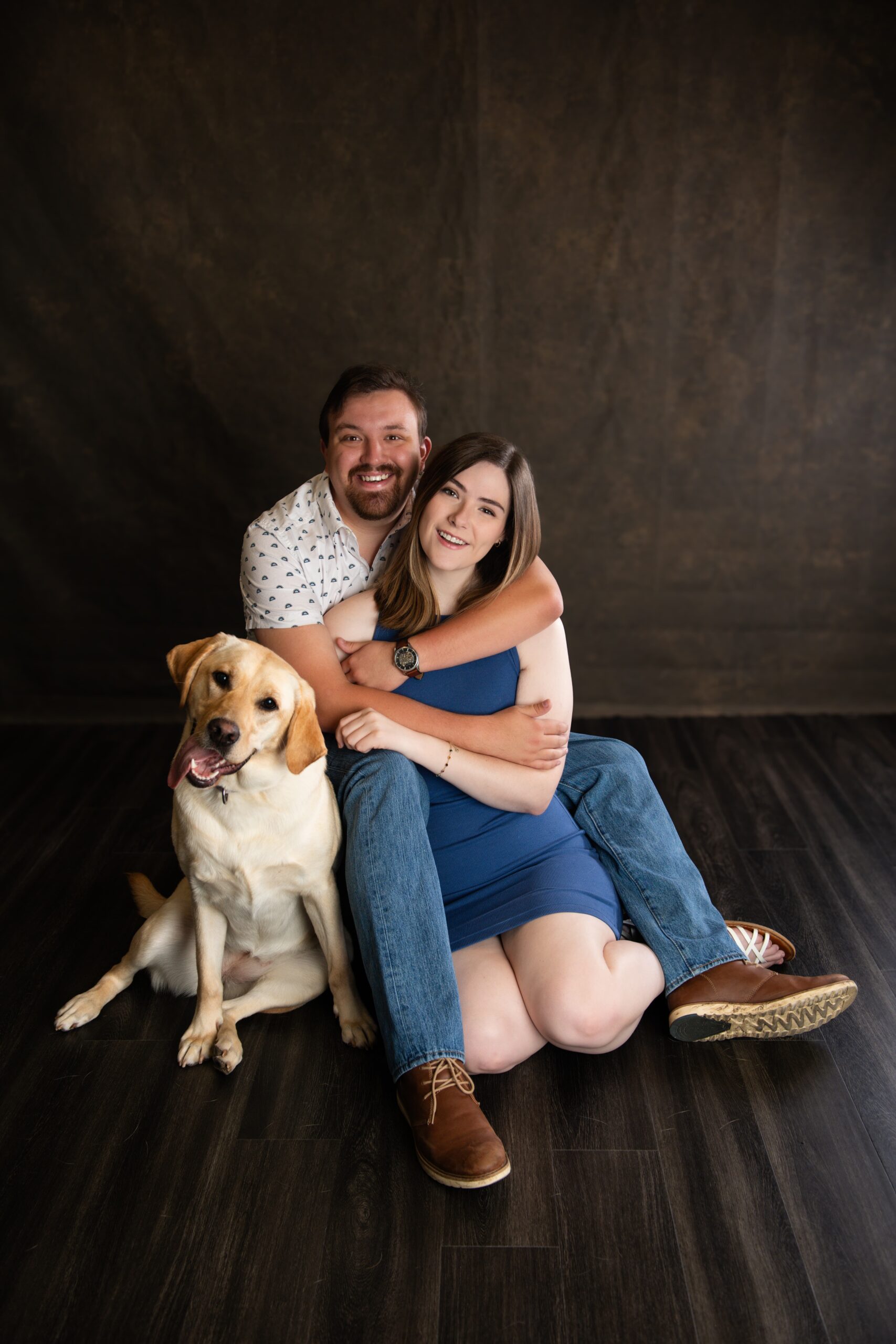 Couple with their yellow Labrador during a studio pet portrait